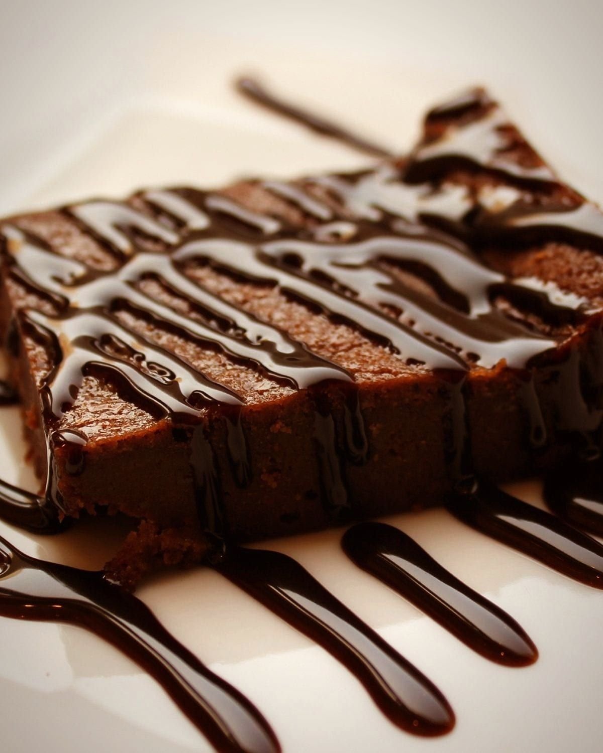 A chocolate brownie slice drizzled with glossy chocolate sauce (representative photo)